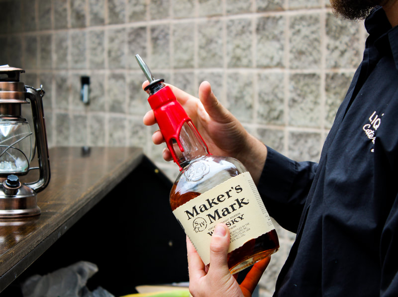 A bartender holding a bottle of Maker's Mark Whisky