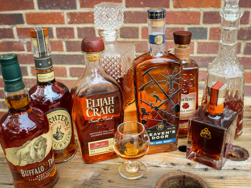 A glass of bourbon in front of a row of whiskey and bourbon bottles